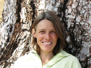  Una foto de perfil de Bárbara Stumpp, sentada, la espalda apoyada en un pino en el bosque de la IslaTenerife.