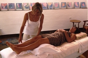 blonde Frau mit langen Haaren liegt entspannnt auf einer Massageliege, zwei Hände werden ihr auf den Brustkorb aufgelegt