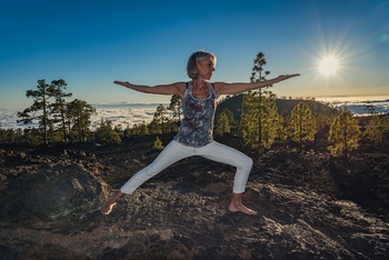 Frau in Yogahaltung Der Held auf einer Berg beim Sonnenuntergang