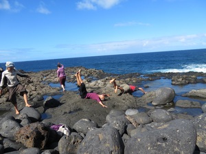 Gruppe von Menschen macht Körperübungen am Felsenstrand auf Teneriffa